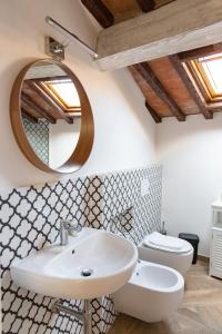 La salle de bains est pourvue d'un lavabo, de toilettes et d'un miroir. dans l'établissement Large 2BR Apartment Near Piazza San Marco, à Florence