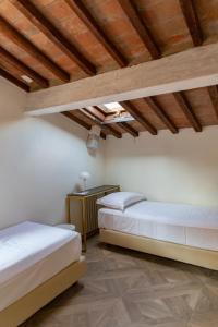 two beds in a room with wooden ceilings at Large 2BR Apartment Near Piazza San Marco in Florence