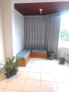 two beds in a room with a window at Apartamento Compartilhado Quarto 3 Oktoberfest in Blumenau