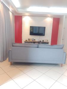 a living room with a couch and a flat screen tv at Apartamento Compartilhado Quarto 3 Oktoberfest in Blumenau