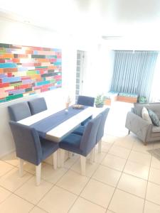 a dining room with a table and blue chairs at Apartamento Compartilhado Quarto 3 Oktoberfest in Blumenau