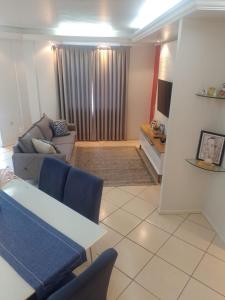 a living room with a couch and a table at Apartamento Compartilhado Quarto 3 Oktoberfest in Blumenau