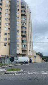 a white van parked in front of a large building at Apartamento Compartilhado Quarto 3 Oktoberfest in Blumenau