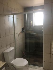 a bathroom with a toilet and a glass shower at Apartamento Compartilhado Quarto 3 Oktoberfest in Blumenau