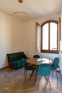 een woonkamer met een tafel en stoelen en een bank bij Large 2BR Apartment Near Piazza San Marco in Florence