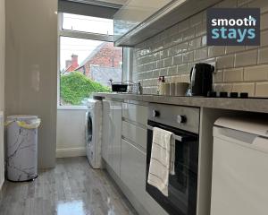 a kitchen with a stove top oven next to a window at Modern 2 Bed Apartment By Smooth Stays Short Lets & Serviced Accommodation Preston With Parking Near Train Station in Preston