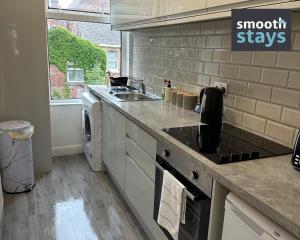 a kitchen with a sink and a stove top oven at Modern 2 Bed Apartment By Smooth Stays Short Lets & Serviced Accommodation Preston With Parking Near Train Station in Preston