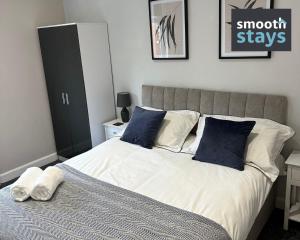 a bedroom with a bed with blue and white pillows at Modern 2 Bed Apartment By Smooth Stays Short Lets & Serviced Accommodation Preston With Parking Near Train Station in Preston