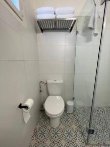 a small bathroom with a toilet and a shower at Bright and Cozy Bauhaus Gem in Ra‘ananna