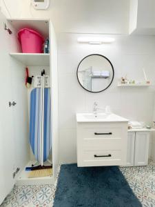 a white bathroom with a sink and a mirror at Bright and Cozy Bauhaus Gem in Ra‘ananna