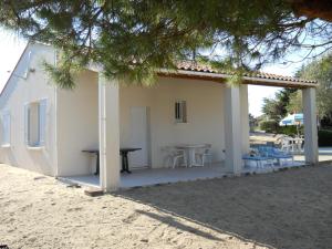 a patio with a table and chairs on the beach at Ile Oléron Près du port de La Cotinière 2 pers. Plage et océan à 50 m in Saint-Pierre-dʼOléron