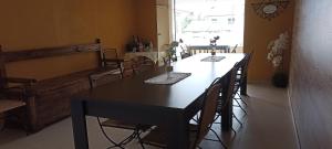 a dining room with a black table and chairs at Vale Poços House in Vinha da Rainha