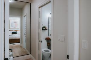 a bathroom with a toilet and a mirror at Heart of Downtown Restored Heritage Home in Vancouver