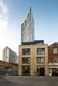 ロンドンにあるChic Studio w/ Balcony - Newly refurbishedのレンガ造りの建物の前の高層ビル