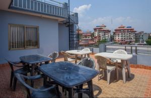 a patio with tables and chairs on a balcony at Three Brothers Apartment and Hotel in Kathmandu
