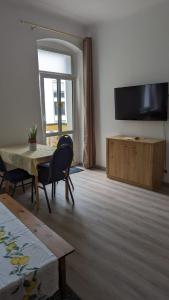 a living room with a table and a flat screen tv at Pension Hubertus in Berlin