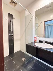 een badkamer met een wastafel en een glazen douche bij The Floorspace Imperial Suites Apartment 2 in Kuching