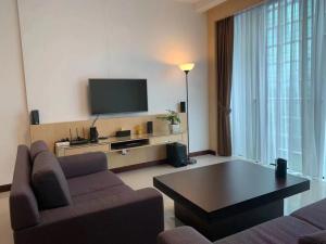 een woonkamer met een bank en een tv bij The Floorspace Imperial Suites Apartment 2 in Kuching