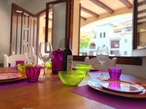 una mesa de madera con copas de vino y una botella de vino en Casa Mi Resort Alcazar by SunshineClub, en Los Alcázares