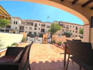 Un patio al aire libre con dos sillas y una mesa. en Casa Resort Mi Alcazar by SunshineClub, en Los Alcázares