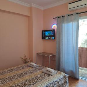 two beds in a room with a tv on the wall at Riga Fereou apartments in Patra