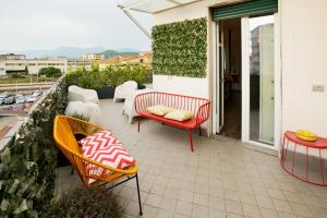 eine Terrasse mit Stühlen und Tischen auf dem Balkon in der Unterkunft Ross House in Nocera Inferiore
