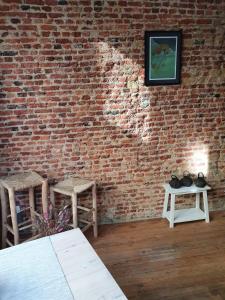 a room with a brick wall with two tables and chairs at Den Gulden Hoorn in Antwerp