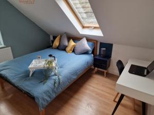 Un dormitorio con una cama azul con una mesa. en What a great location in Bromley with 4 bedrooms!, en Bromley