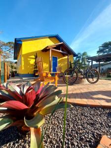 a yellow house with a bike parked in front of it at Pousada Nonno Fiorindo in Volta Grande