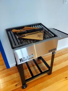 a metal grill with wooden utensils in a room at Pousada Nonno Fiorindo in Volta Grande