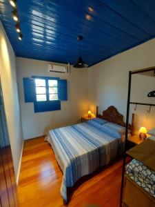 sypialnia z łóżkiem i niebieskim sufitem w obiekcie Pousada Nonno Fiorindo w mieście Volta Grande