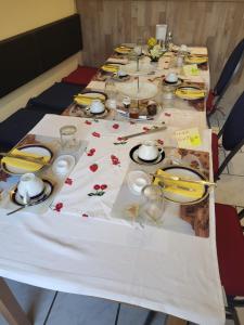 a table with a white table cloth with plates and dishes at Pension Hubertus in Berlin