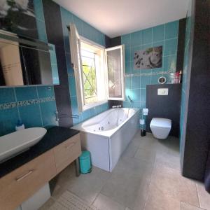 a bathroom with a tub and a toilet and a sink at Belvédère du midi in Ayguesvives