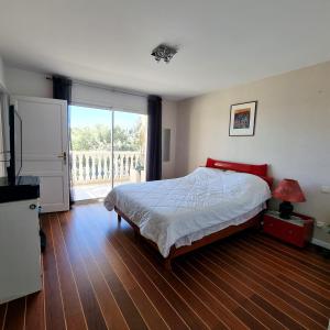 ein Schlafzimmer mit einem Bett und einem großen Fenster in der Unterkunft Belvédère du midi in Ayguesvives
