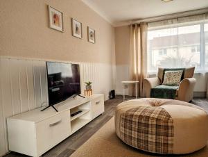 a living room with a television and a bed and a chair at Lavender View in Grantham