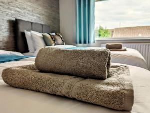 una pila de toallas sentadas encima de una cama en Lavender View en Grantham