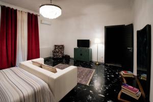 ein Wohnzimmer mit einem weißen Sofa und roten Vorhängen in der Unterkunft Ross House in Nocera Inferiore