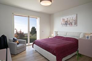a bedroom with a bed and a large window at LUXURY VILLA ORIZZONTI - Regarda Travel in Bardolino +58 photos
