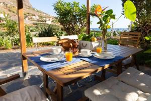 エルミグアにあるCasa Rural El Arenalの木製テーブル(食べ物付)が備わるパティオ