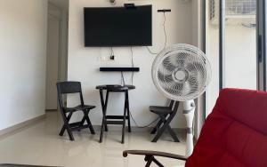 - un salon avec un ventilateur, des chaises et une table dans l'établissement Apartamento - Tocaima, à Tocaima