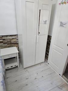 1 dormitorio con puerta blanca, cama y mesa en Habitación privada en Hospitalet de llobregat, en Hospitalet de Llobregat