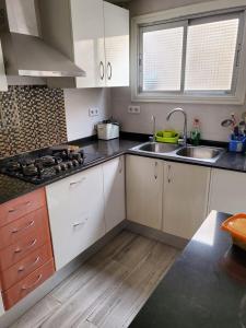 una cocina con armarios blancos y fregadero en Habitación privada en Hospitalet de llobregat, en Hospitalet de Llobregat