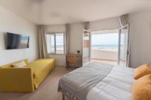 a bedroom with a bed and a view of the beach at Hôtel Casa Marina in Saintes-Maries-de-la-Mer