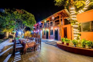 un restaurant avec des tables et des chaises en face d'un bâtiment dans l'établissement Catba Papillon Garden Bungalows & Resort, à Cat Ba