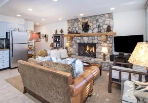 a living room with couches and a stone fireplace at Village Center 1-e in Vail