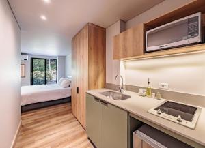 a kitchen with a sink and a bed in a room at The Somos Flats Central Poblado in Medellín