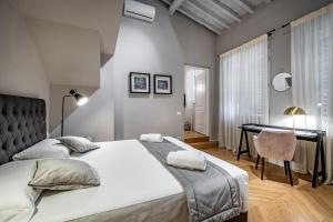 ein Schlafzimmer mit einem großen Bett und einem Schreibtisch in der Unterkunft Hs4U Ricasoli Luxury apartment near Duomo N.1 in Florenz