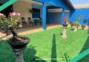 a garden with two vases with flowers in it at CASA CRAVOS C/ PISCINA in Foz do Iguaçu