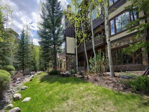 a house with a yard in front of a building at Arrowhead Village Condo - 104 Aspenwood Lodge in Edwards