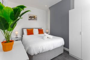 a bedroom with a bed and a potted plant at Flatzy - 12 Person Townhouse with Pool Table and Ping Pong in Liverpool